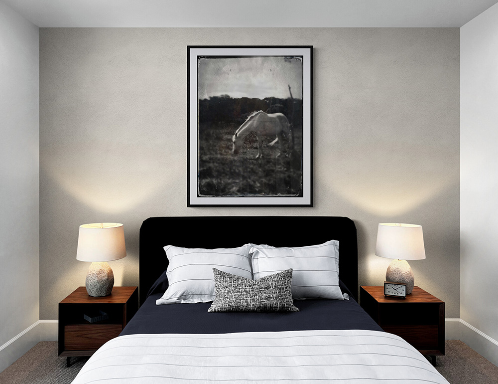 Image of a bedroom with a tintype style photo of a horse on the wall
