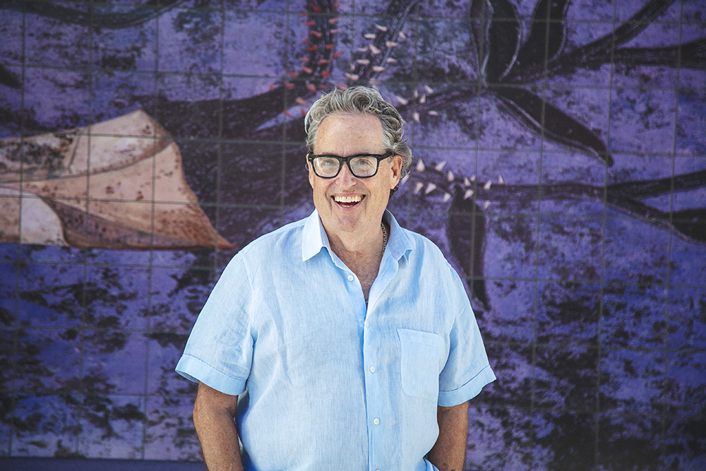 Man wearing glasses and blue shirt smiles at the camera
