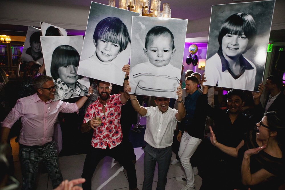 Photo of guests holding up enlarged photos of a child