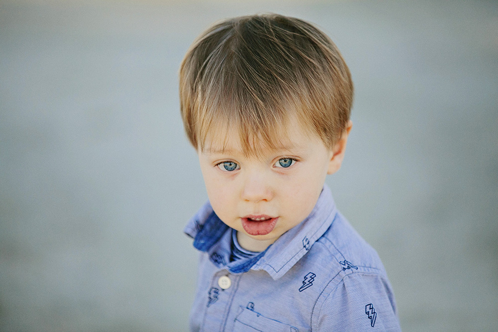 Toddler with striking blue eyes gazes up at the camera
