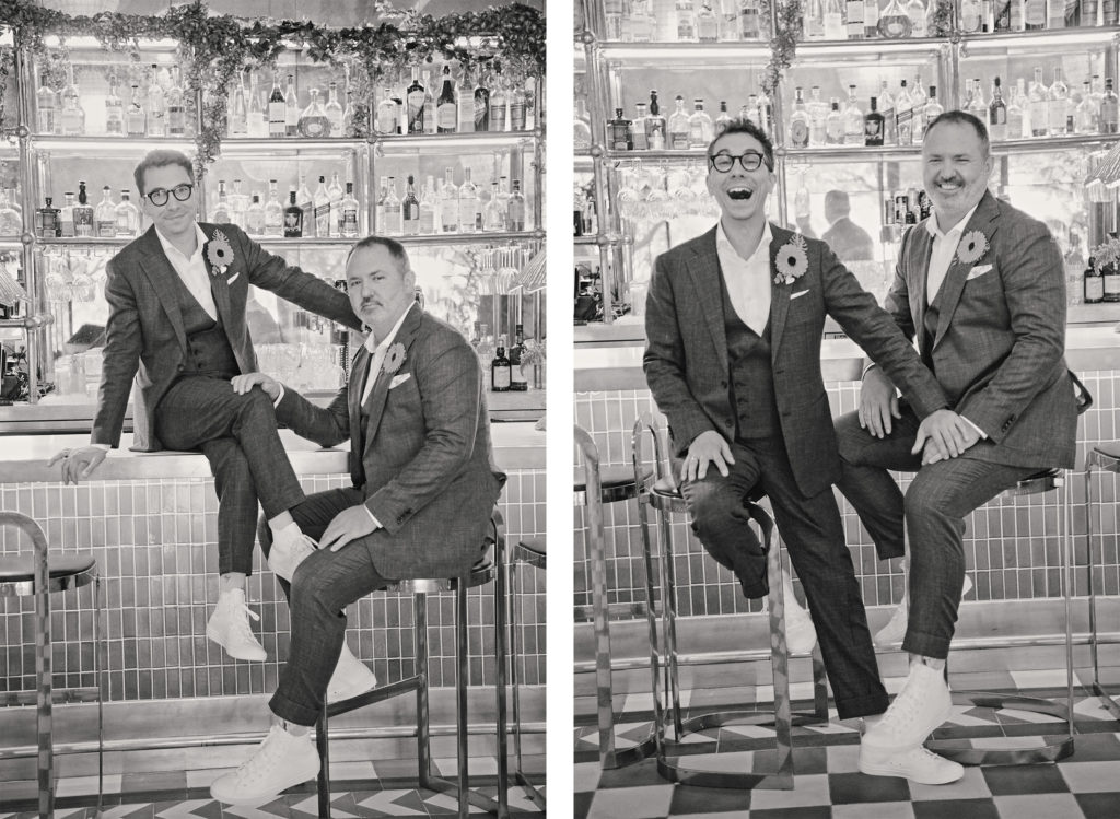 Newlywed gentlemen pose for fun photos at the hotel bar.