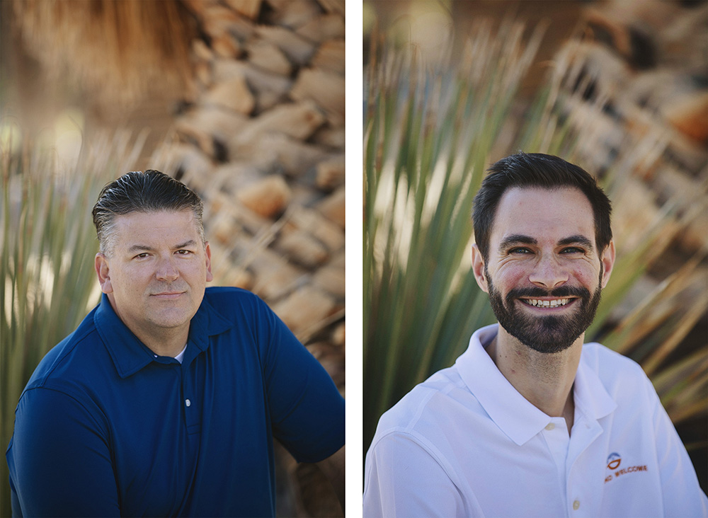 Two dark haired gentlemen pose for headshots in a desert park